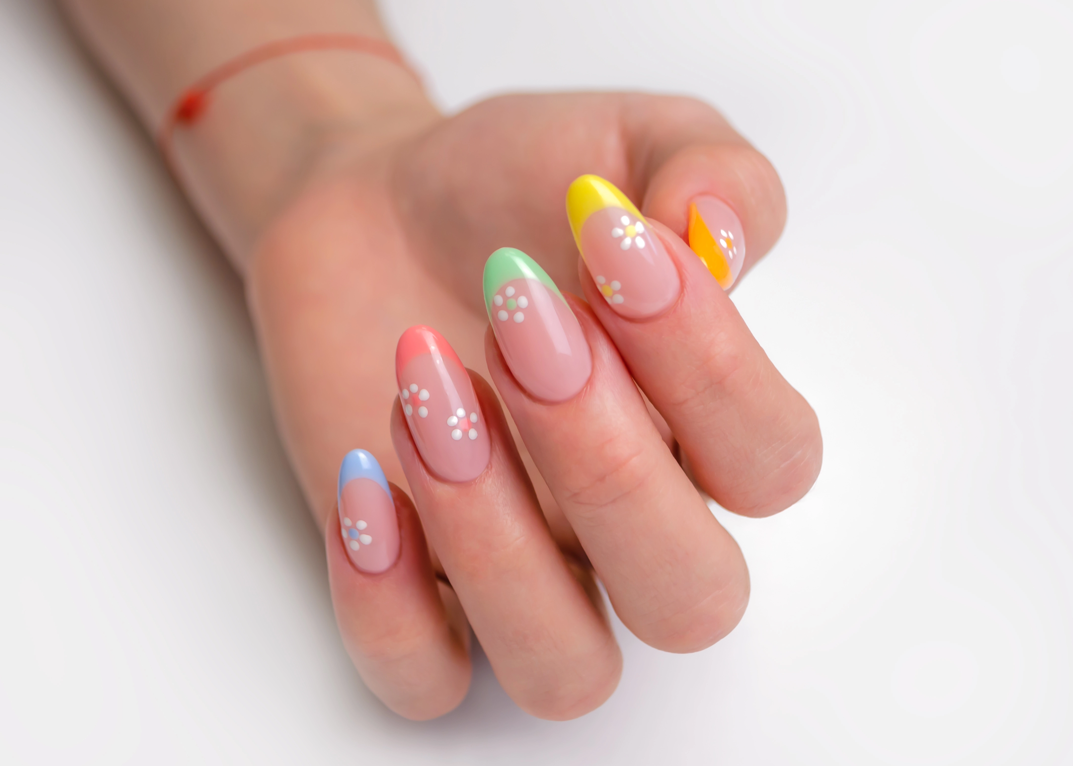 Pink and yellow manicure with small white flower designs